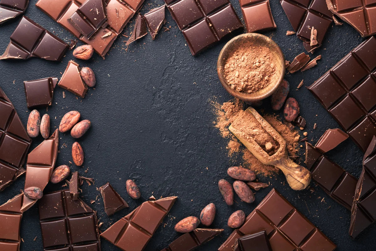 A side-by-side comparison of cacao powder and cocoa powder, showing their different colors and textures in wooden bowls.